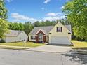 Charming home featuring a well-manicured lawn, brick accents, and a two-car garage with a lovely blue sky overhead at 1835 Patrick Mill, Buford, GA 30518