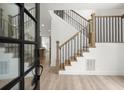Elegant entryway featuring wood and metal stair railings and modern wood flooring at 32 Wadley Nw St, Atlanta, GA 30314