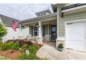 Inviting front porch with decorative plants, rocking chairs, and an American flag at 98 Heritage Pointe Dr, Villa Rica, GA 30180
