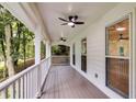 Covered porch with ceiling fans and views of the surrounding trees, creating an ideal outdoor retreat at 2055 Timberland Dr, Cumming, GA 30040