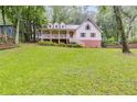 Charming two-story home with a welcoming front porch and lush green lawn surrounded by mature trees at 2055 Timberland Dr, Cumming, GA 30040