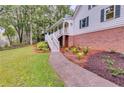 Landscaped yard with a walkway leading to the charming two-story home featuring a welcoming front porch at 2055 Timberland Dr, Cumming, GA 30040