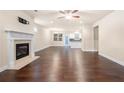 Open-concept living room with hardwood floors and fireplace, flowing into the kitchen at 2431 Kingston Heath Way, Marietta, GA 30008