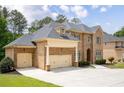 Stately brick home boasts a three-car garage, lush lawn, and classic architectural design at 3512 Centerville Rosebud Rd, Snellville, GA 30039