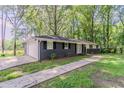 Home with dark brick, attached garage, fresh green lawn, and sidewalk to the front door at 545 Fayetteville Rd, Fairburn, GA 30213