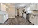Kitchen featuring granite countertops, stainless steel appliances, white cabinetry and plank flooring at 545 Fayetteville Rd, Fairburn, GA 30213