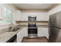 Updated kitchen featuring stainless steel appliances, granite countertops, and sleek white cabinets at 733 San Fernando Se Dr, Smyrna, GA 30080