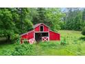 Classic red barn with white trim, featuring a traditional design set against a green backdrop at 901 N Van Wert Rd, Villa Rica, GA 30180