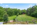 Scenic view of a sprawling property, a red barn, lush greenery, and horse grazing at 901 N Van Wert Rd, Villa Rica, GA 30180