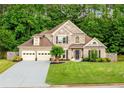 Charming two-story brick home with a three-car garage and lush green lawn at 3707 Lance Bluff Ln, Duluth, GA 30097