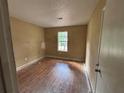 A bedroom featuring hardwood floors, a window, and a door at 1090 Forest Path, Stone Mountain, GA 30088