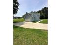 Side view of a two-story home with light blue siding and an attached garage on a grassy lawn at 1201 Saint Andrews Dr, Auburn, GA 30011