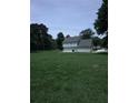 A wide grassy lawn with a view of a two-story home with light blue siding and an attached garage at 1201 Saint Andrews Dr, Auburn, GA 30011