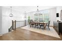 Elegant dining room with hardwood floors, modern lighting, and large windows at 6807 Prelude Dr, Atlanta, GA 30328