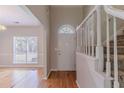 Bright foyer features hardwood floors, white staircase, and a front door with decorative window at 12241 Cypress Way, Fayetteville, GA 30215