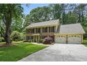 Traditional brick home with a spacious driveway and a well-kept lawn, surrounded by mature trees at 878 Park Creek Sw Ct, Marietta, GA 30064