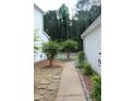 Property features a stone and concrete walkway leading to an easily maintained side yard at 1132 Britley Park Ln Ln, Woodstock, GA 30189