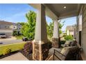 Inviting front porch with stone pillar accents and comfortable seating, perfect for relaxing and enjoying the outdoors at 122 Grove View Rd, Woodstock, GA 30189