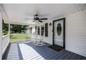 View of the covered front porch with ceiling fan and rocking chairs at 4067 Lenora Church Rd, Snellville, GA 30039
