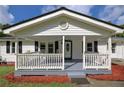 Close-up of a white, covered front porch with rocking chairs and black window shutters at 4067 Lenora Church Rd, Snellville, GA 30039