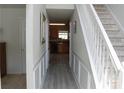 Hallway view leading to the kitchen, featuring wood-look floors and white wainscoting at 4450 Ivy Fork Dr, Loganville, GA 30052