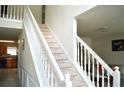 Bright foyer showcasing a staircase with white banisters and carpeted steps at 4450 Ivy Fork Dr, Loganville, GA 30052