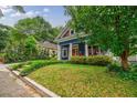Quaint home features a grassy front yard with mature shade trees and a delightful blue facade at 549 Atwood Sw St, Atlanta, GA 30310