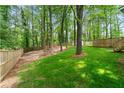 Spacious backyard featuring lush green grass and a wooden fence at 2110 Argyle Se Dr, Smyrna, GA 30080