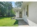 Close up view of the painted brick front entrance of this home with a well manicured lawn and mature trees at 2110 Argyle Se Dr, Smyrna, GA 30080