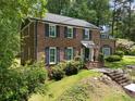 Two-story brick home with lush greenery, featuring black shutters and a well-maintained lawn at 2719 Cravey Ne Dr, Atlanta, GA 30345