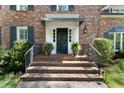 Inviting front porch with brick steps, potted plants, and a classic black front door at 2719 Cravey Ne Dr, Atlanta, GA 30345