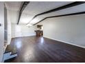 Spacious living room with dark hardwood floors, exposed beam ceiling, and a decorative chandelier at 6225 Pebble Dr, Douglasville, GA 30135