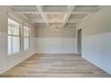 Spacious dining room featuring coffered ceilings, wainscotting, and neutral paint at 162 Haverling Pass, Hampton, GA 30252