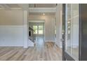 Bright foyer with hardwood floors, wainscotting, and an open staircase to the second floor at 162 Haverling Pass, Hampton, GA 30252
