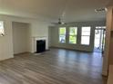 Bright living room with a fireplace, ceiling fan, and large windows providing abundant natural light at 241 Saratoga Dr, Acworth, GA 30102