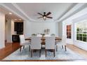 Elegant dining room with hardwood floors, tray ceiling, modern fan, and bright natural light at 265 Dogwood Walk Ln, Norcross, GA 30071