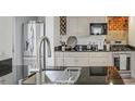 Well-lit kitchen featuring stainless steel appliances, white cabinets, granite countertops and exposed brick wall at 3330 W Shadowlawn Ne Ave, Atlanta, GA 30305