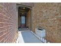 Brick entryway of townhome with a solid front door, plants, and a small walkway at 1929 Brightleaf Way, Marietta, GA 30060