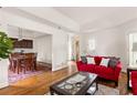 Open-concept living space with hardwood floors, a red sofa, and seamless flow to the dining area at 320 Kirk Rd, Decatur, GA 30030