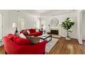 Bright living room with tray ceilings, hardwood floors, a fireplace, and red sofas at 320 Kirk Rd, Decatur, GA 30030