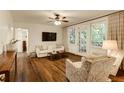 Bright living room with hardwood floors, neutral furniture, and a doorway to the screened balcony at 2230 Peachtree Ne Rd # A-3, Atlanta, GA 30309