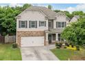 Charming two-story home featuring stone accents, a two-car garage, and a manicured front yard at 3805 Alden Pl, Cumming, GA 30028