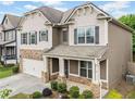 Charming two-story home featuring stone accents, gray shutters, and a covered front porch at 3805 Alden Pl, Cumming, GA 30028