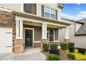 Inviting front porch with stone columns and manicured landscaping, a perfect entry to the home at 3805 Alden Pl, Cumming, GA 30028