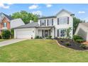 Charming two-story home with a well-manicured lawn, black shutters and a two car garage at 565 Barsham Way, Johns Creek, GA 30097