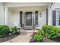 Cozy front porch with white Adirondack chairs, beautiful shrubs and custom front door at 565 Barsham Way, Johns Creek, GA 30097