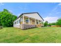 Landscaped yard surrounds this charming home with a covered front porch and brick foundation at 6054 Heritage Se Way, Mableton, GA 30126