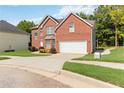 Well-maintained two-story brick home with a spacious driveway and lush green lawn at 1127 Oak Hollow Ct, Hampton, GA 30228