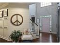 Inviting foyer with stylish decor, featuring hardwood floors, a unique peace sign accent, and a charming staircase at 1199 Kenway Se Cir, Smyrna, GA 30082
