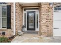 Close up of a brick home's beautiful front door and stone walkway with garden decor at 1525 Camden Cove Dr, Cumming, GA 30040